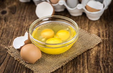 Wooden table with Raw Eggs (detailed close-up shot; selective focus)