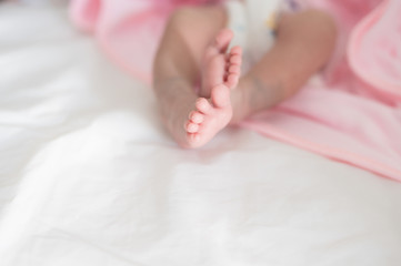 Obraz na płótnie Canvas Baby sleeping on the bed.Newborn baby foots and relax action with pink blanket.Happy time family concept.
