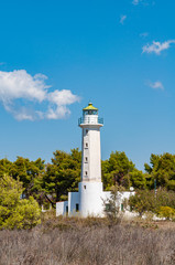 Fototapeta na wymiar Halkidiki, Greece - September 01,2019: Possidi lighthouse. Near Possidi cape (Miti beach) there is an old lighthouse, built in 1864. Ιts height is 14,5 meters and the height of its light is 23 meters.