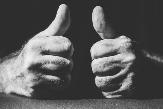 close-up of two hands showing their thumbs up