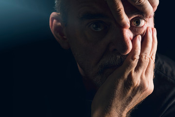 portrait of a man who emphasizes an eye with his hands