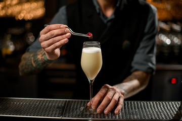 Close-up of bartender adding flower with pincers