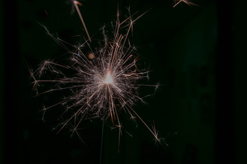 sparks from a lit sparkler on a dark background