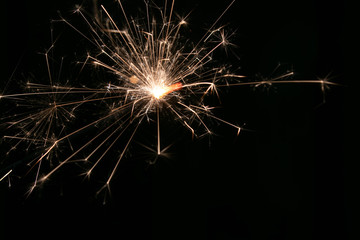 sparks from a lit sparkler on a dark background