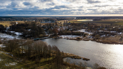 Obraz premium Beautiful winter lake on cloudy sky background. Aerial view.