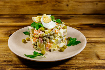 Traditional Russian festive salad Olivier on wooden table