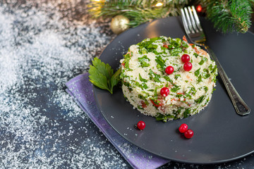 Tabbouleh  salad in a round plate on a wooden background.