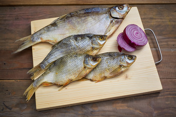 Dried fish on a wooden cutting board.