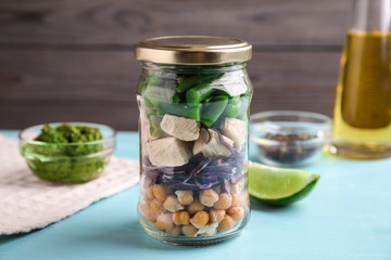 Glass jar with healthy meal on light blue wooden table