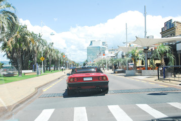 Red car driving to the coast, Tauranga, New Zealand