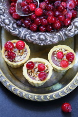 Cupcakes with cranberries and hazelnuts on a black background