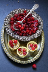 Cupcakes with cranberries and hazelnuts on a black background