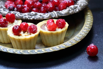 Cupcakes with cranberries and hazelnuts on a black background