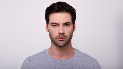Naklejka premium Portrait of a young handsome guy in a gray t-shirt.