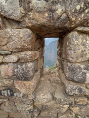 Stone window at Machu Picchu, mountains in the background