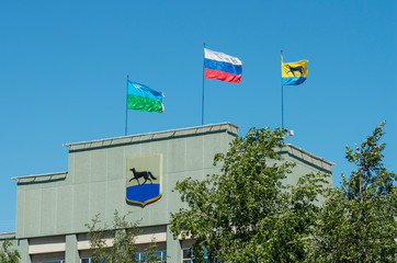 Surgut, City Council building. Flag and coat of arms of Surgut.