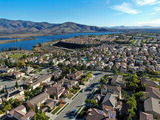Aerial view of identical residential subdivision house with big lake and mountain on the background...