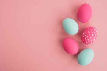 Colorful easter eggs in pastel colors on a light pink background. Minimal composition. Top view, flat lay, copy space