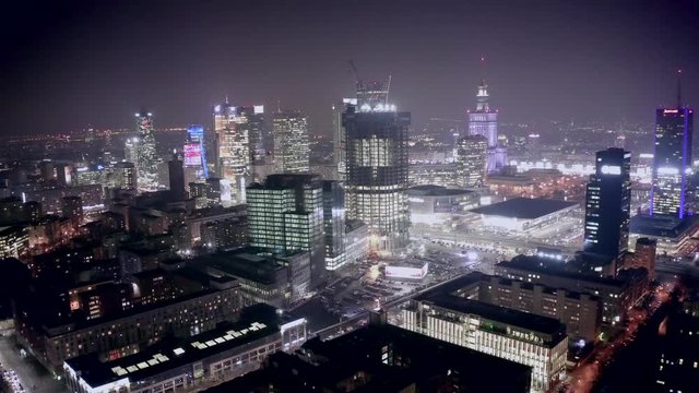 Drone shot at night cityscape with skyscrapers and buildings on a foggy night. Warsaw-Poland. 04. December. 2019. Aerial view of the night city with traffic and skyscrapers in the fog.