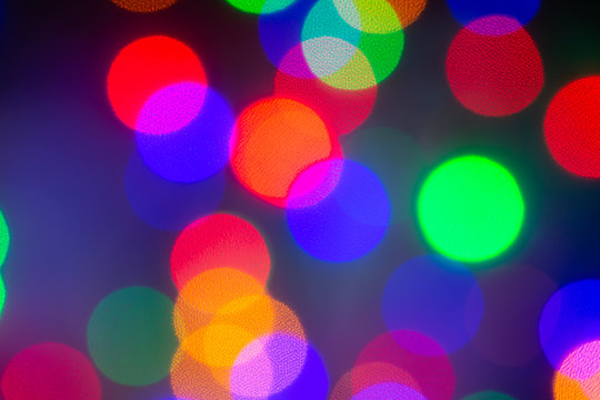 Abstract, unfocused image with colorful bright bubbles in the black background. Modern pattern for design and backdrop.