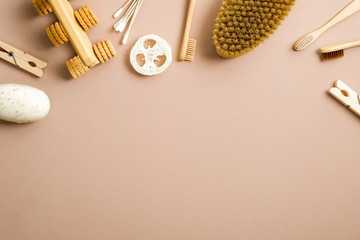 Zero waste concept. Set of eco friendly bathroom items: homemade soap, wooden pins, luffa sponge, bamboo toothbrushes, ear sticks on brown background with copy space. Flat lay, top view