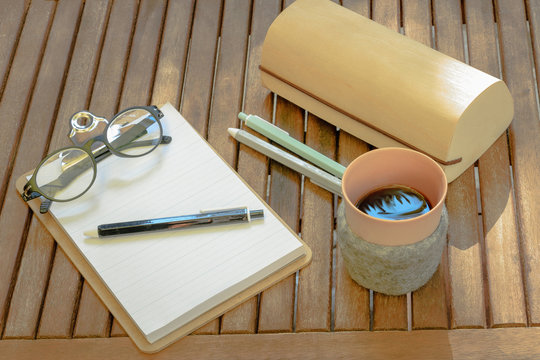 Bureau en bois avec un café avec une couverture en laine une paire de lunettes - bureau écologique avec un bloc-note en bois et du papier recyclé une trousse de stylo en bois recyclé