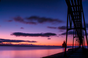 Fototapeta na wymiar silhouette of lighthouse and pier at sunrise