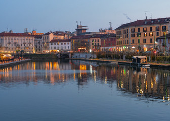 the houses of the characteristic Navigli district are reflected in the dock (Darsena) after sunset.Milan - Italy