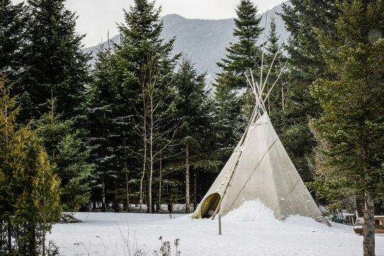 Teepee traditionnel d'indien dans une forêt en Amérique du Nord dans la neige au milieu des sapins