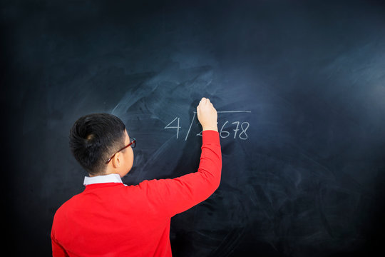 Back view of an adorable boy solving calculations - Powered by Adobe