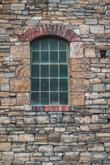 Fototapeta na wymiar Fester von einer alten Fabrik, Steinmauer