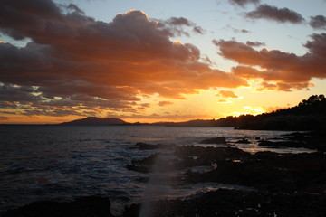 Fototapeta na wymiar Sunset sea rocks mountain splashing water