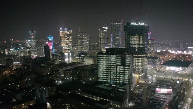 Aerial view of bright lights and nightlife in the business center of Warsaw-Poland. 03. December. 2019. Drone fired at a city at night with skyscrapers in the fog in the business district of Warsaw.