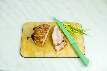 On the cutting board lies a delicious bacon with onions.