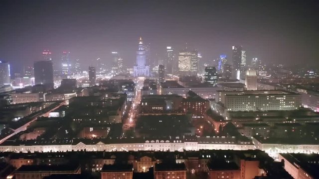 Aerial view of a cityscape on a foggy night in the center of Warsaw-Poland. Drone flies over the nightly architecture of downtown Warsaw.
