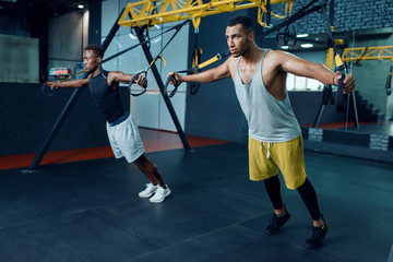 Two athletes at stretching exercise machine