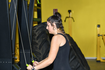 Fototapeta na wymiar Woman using a cable row machine at the gym