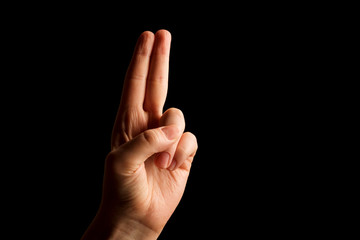 Hand Showing Sign of U Alphabet in American Sign Language (ASL), isolated on black background. Sign language