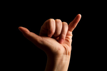 Hand Showing Sign of Y Alphabet in American Sign Language (ASL), isolated on black background. Sign...