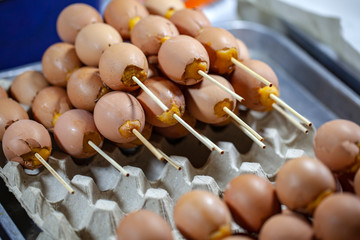 At the Market, Thailand, fried eggs on wooden skewers