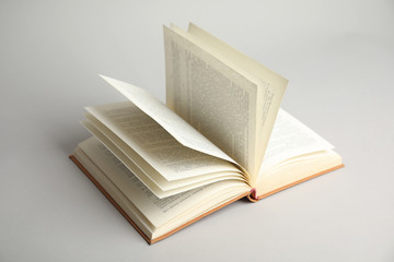 Open old hardcover book on light grey background