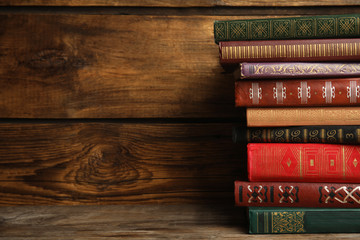 Collection of different books on table against wooden background. Space for text