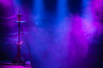 The classic hookah. Beautiful background, with colored rays of light and smoke. The concept of hookah Smoking. © puhimec