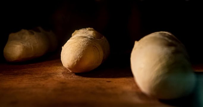 Warm fresh baguette in a bakery. Making bread and eco production. Manufacturing process working hard. Bakery shop and selling rooty. Baking Italian bio bread in oven. Time lapse footage of cooking.