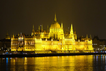 Fototapeta premium Budapest parliament house at night. Illuminated Hungarian parliament building with reflection in Danube river.