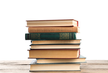 Stack of old vintage books on wooden table against white background