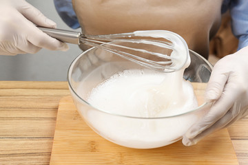 Woman making natural handmade soap at wooden table, closeup