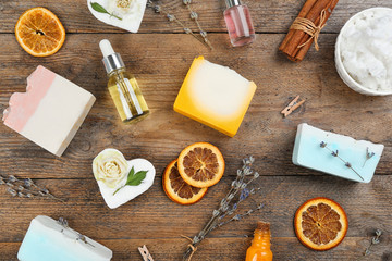 Flat lay composition with natural handmade soap and ingredients on wooden table