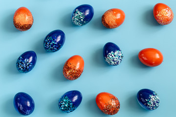 Beautiful Easter blue background with blue and orange decorative eggs .