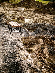 Metal bench installed, park renovation. Ground work in progress. Selective focus.